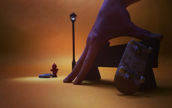 Photo d'une main posée sur un banc et un skateboard